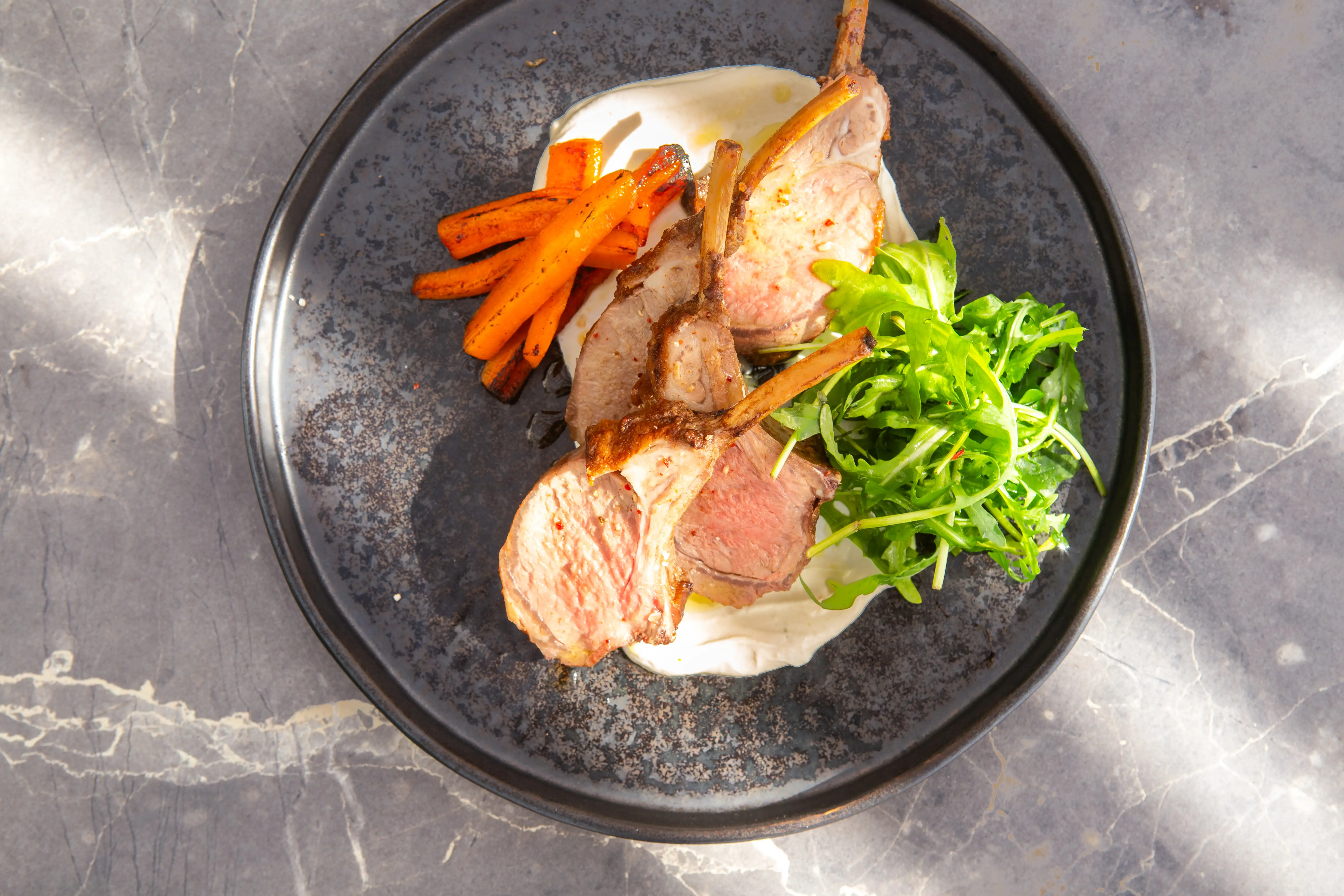 Grilled lamb chops with charred carrots and greens