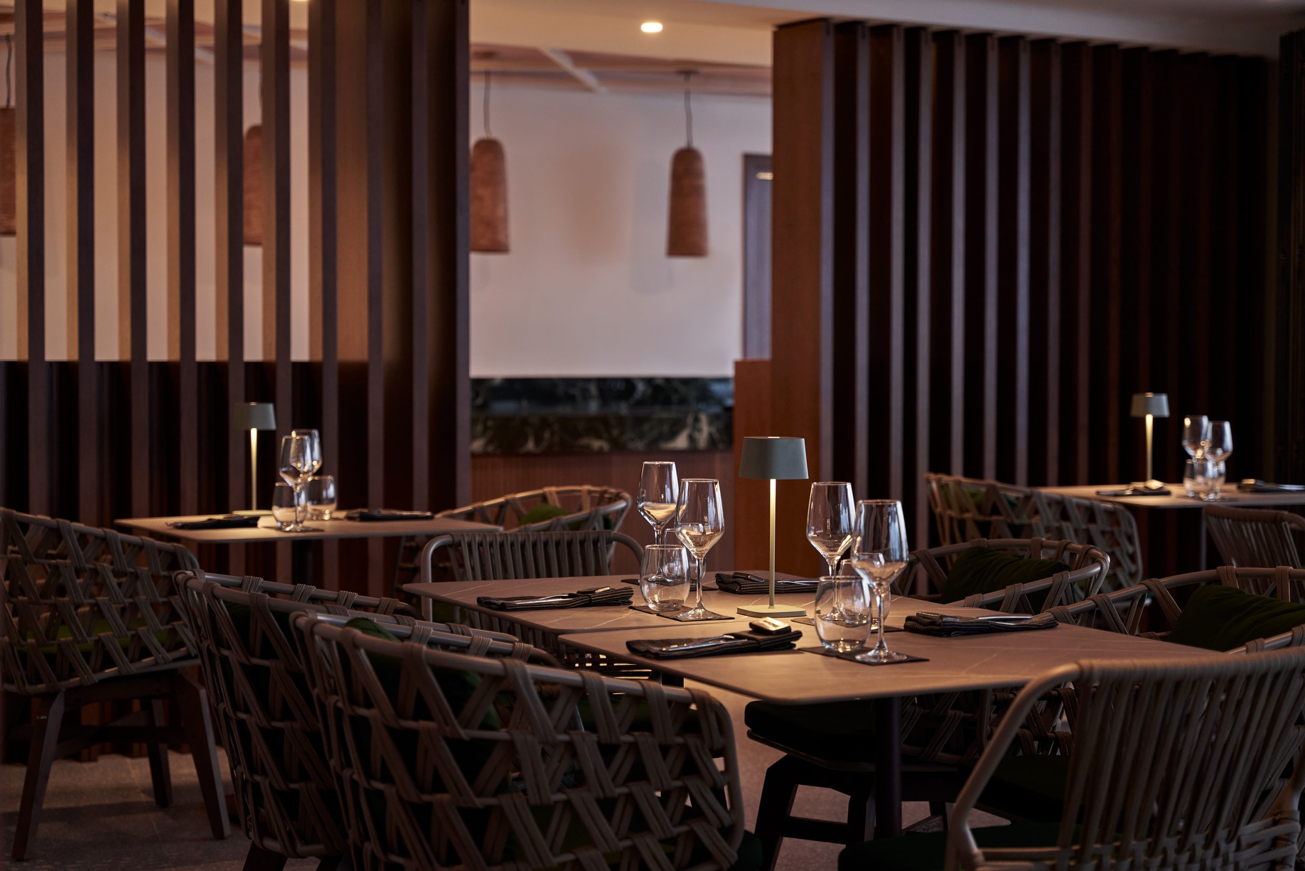 Elegant dining room at Narcissus Restaurant, Kouros Hotel Mykonos, with warm table lighting and contemporary seating